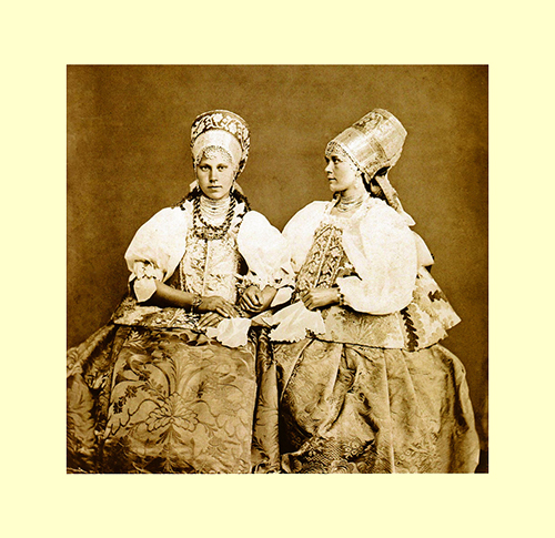 Decisamente polisemico questo ritratto eseguito da Ivan Brandenburg nel 1867 a una coppia di ragazze della regione di Arcangelo. L’intenzione di enfatizzare i costumi e i loro disegni floreali è certamente evidente; le braccia intrecciate fanno inoltre supporre la presenza di un legame parentale e, o l’adesione a una prospettiva ritrattistica di genere che raccomanda ai soggetti femminili l’assunzione di pose improntate alla tenerezza e alla dolcezza. Il fatto, infine che una delle due giovani sia stata raffigurata di profilo suggerirebbe un’istanza antropometrica unitamente a quella, etnografica, per meglio far apprezzare il voluminoso e assai elaborato copricapo. foto 1